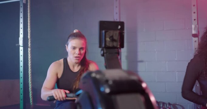 Three rowers starting on cue, curly woman pulling, tank woman matching man in orange powering pulls