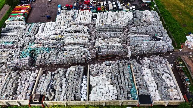 Large stacks of compressed recyclable materials organized in an outdoor industrial yard