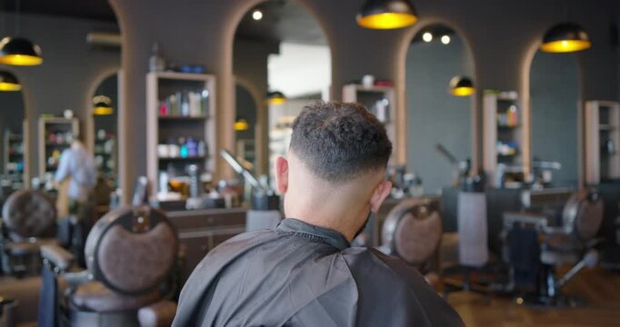 African American barber trimming and blending client hair at shop at client request with clippers
