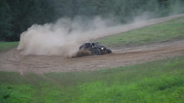 Modified Ultra4 V8 off-road car kicking up dust before hill climb