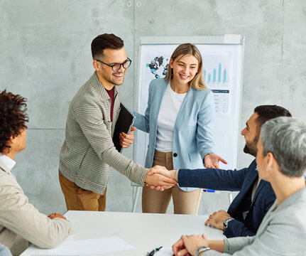 portrait of  a young businessman and businesswoman shaking hands introducing each other in the office