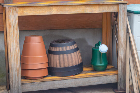 Plant pots and watering can supplies on a garden bench