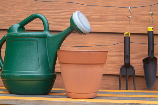 Plant pots and watering can supplies on a garden bench