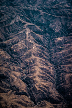 Aerial view of the rugged, terraced landscape featuring deep valleys and intricate soil patterns, Nairobi, Nairobi County, Kenya.