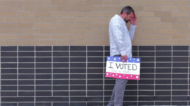 Man holding a humorous, satirical campaign sign reading I Voted for a nap, capturing themes of election fatigue, voting fatigue, and political burnout