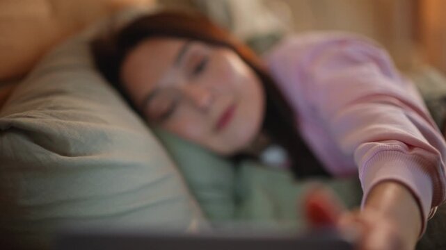 Woman hands reaching smartphone on bedside table awakening in bedroom closeup.