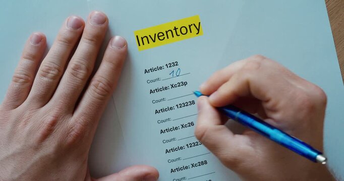 Close-up of a person filling out an inventory checklist on paper with a pen. Stock management, warehouse documentation, inventory control, and business administration concept.