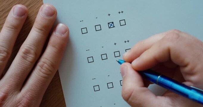 Close-up of a person marking responses on a rating scale form. Evaluation, assessment, survey, feedback, quality control, and data collection concept.