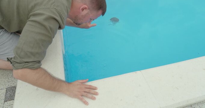 A man reacts to unpleasant odor coming from a swimming pool, indicating poor water quality and hygiene issues. Highlights guest discomfort and maintenance problems in a hotel or vacation setting.