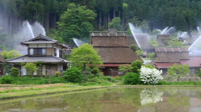 水田とカヤブキ民家の放水