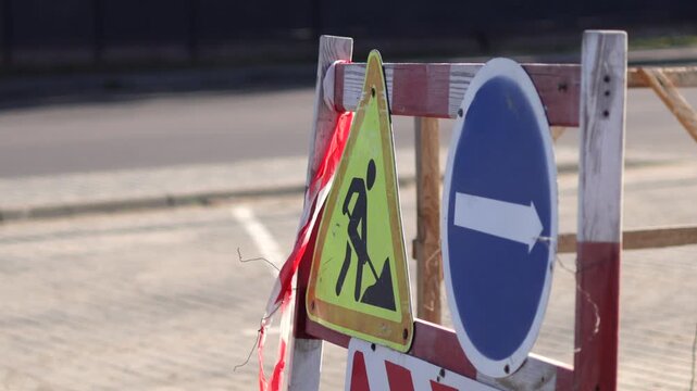Construction Work in an Industrial Area With Warning Signs and Barriers Placed Around the Site During the Day