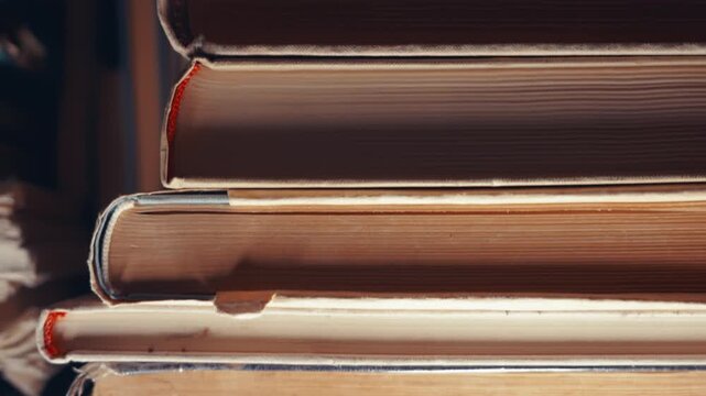 Stacked Antique Books Close-Up &mdash; Slow Tilt-Up Shot | Worn Hardcover Spines with Aged Paper Texture | Vintage Library Knowledge Concept
