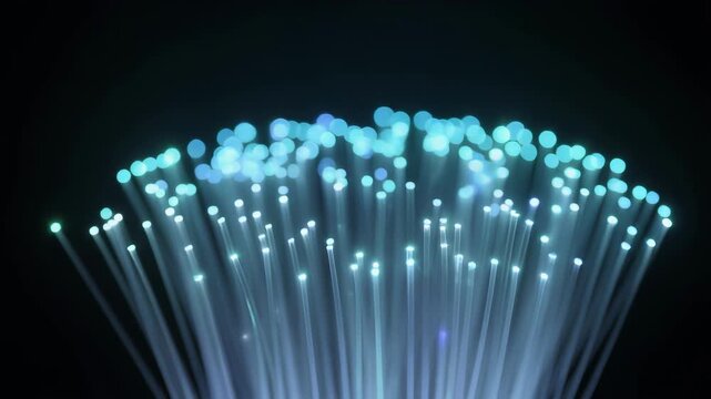 Blue fiber optic cable bundle glows against dark background for data network technology
