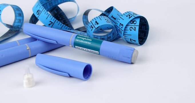 Moving camera layout of blue semaglutide glp1 medication pens for subcutaneous diabetes care and obesity over white background desk