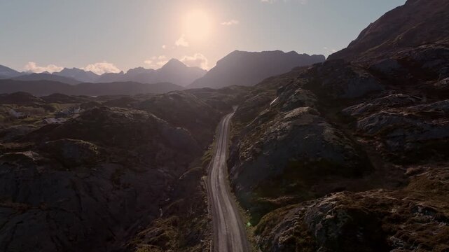 Aerial view of a narrow winding mountain road at sunset