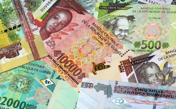 Guinean franc money banknotes bunch on table. Guinea bills of GNF currency close up