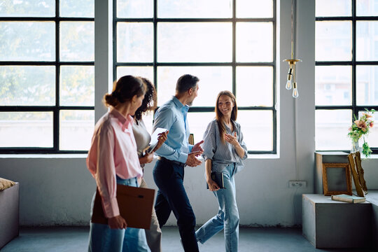 Happy business team talking while walking through office.