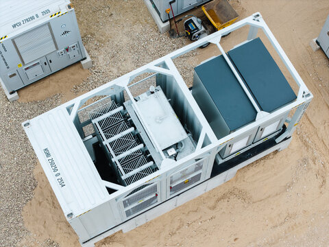 Aerial view of a containerized industrial power transformer unit with metal framing and technical equipment situated on a gravel site in Suntazi, Ogre Municipality, Latvia.