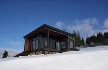 Modern black wooden cottage on snowy mountain in Ukraine  © Ayman Alakhras