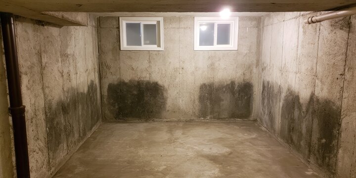 Basement with stained concrete walls and two small windows