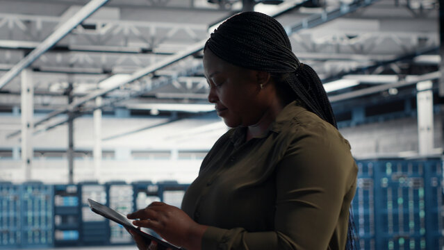 IT specialist uses tablet in a data center to upgrade server hardware and improve workload capacity.