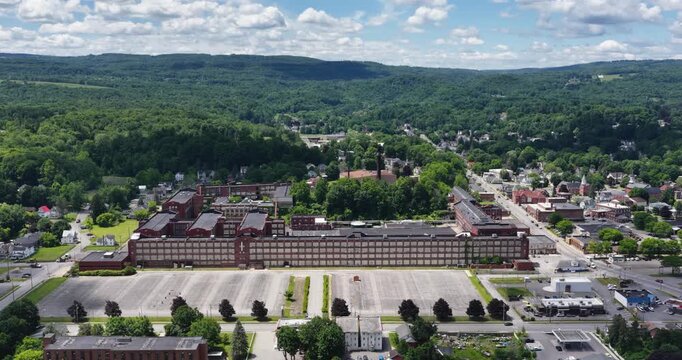 LLION, NY, USA - June 24, 2026: Afternoon summer aerial video of downtown, business district, LLION, NY.  Former Remington Arms factory brick building.