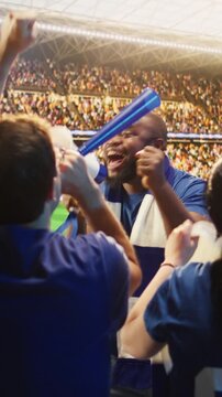 Vertical video: Passionate football fan shouts through megaphone in stadium, leading crowd during match for fan culture, stadium atmosphere and team support content.