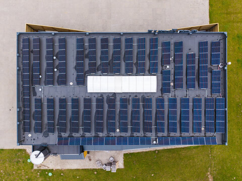 Aerial view of a cheese production facility roof covered with numerous solar panels in Ikskile, Ogre Municipality, Latvia.