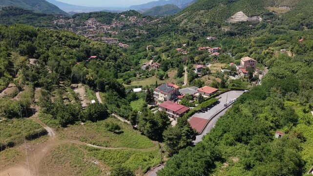 Aerial view of Croce di Cava near Cava de' Tirreni in Campania, Italy, showing a mountain valley, hillside homes, green vegetation and an open pit limestone quarry
