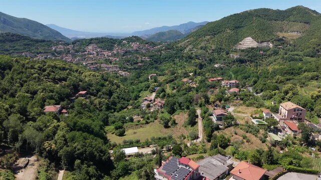 Aerial view of Croce di Cava near Cava de Tirreni in Campania, Italy, showing a green mountain valley, scattered homes, winding roads and an open pit limestone quarry