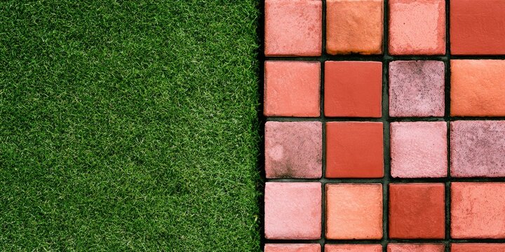 Textured pattern of vibrant green grass juxtaposed with a grid of warm-toned square tiles