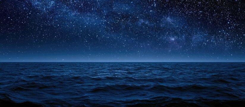 Deep blue ocean beneath a vast, star-filled night sky