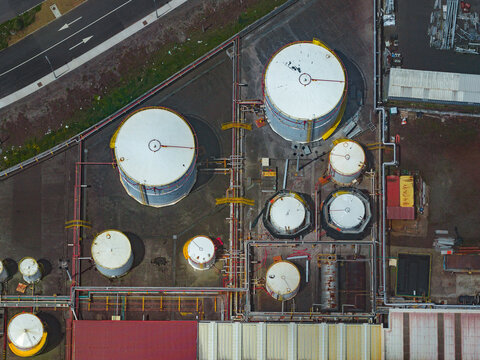 Aerial view of the Tecnovia Acores industrial facility featuring various white cylindrical storage tanks and complex piping networks in Rabo de Peixe, Acores, Portugal.