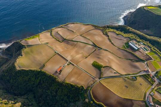 Aerial view of agricultural fields and coastal cliffs in the rural landscape of Salga, Azores, Portugal.