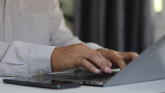 Businessman using laptop computer to provide troubleshooting support. Online IT customer support. Remote help desk chat for technical support and customer service. Freelancer working at home office.