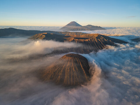 Aerial view of the volcanic landscape of Bromo Tengger Semeru National Park with Mount Bromo rising above a sea of clouds at sunrise in Probolinggo, East Java, Indonesia.
