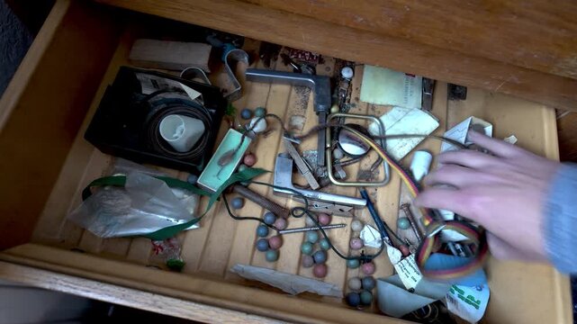 Close-up of accumulated household items being removed from storage. Represents decluttering, fresh starts, moving house, organization, and simplifying daily life.