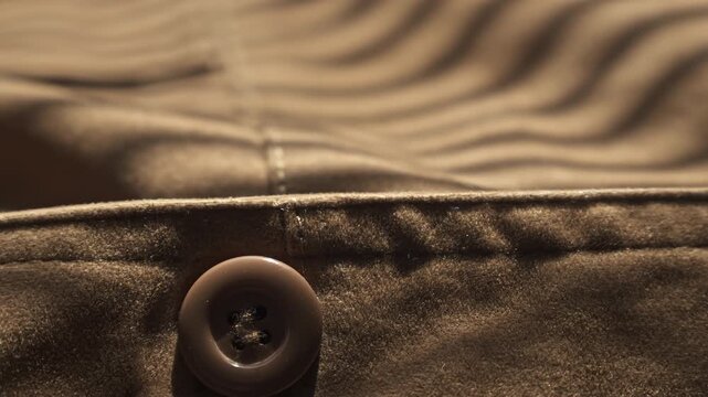 Cinematic close up slider shot revealing the soft, high-quality texture of a brown suede jacket and its detailed stitching. Perfect for fashion, craftsmanship, and tactile storytelling.
