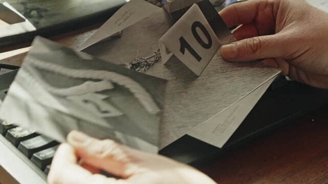 An investigator examines evidence images before documenting findings on a computer. Ideal for crime, investigation, detective work, mystery, and case file storytelling.
