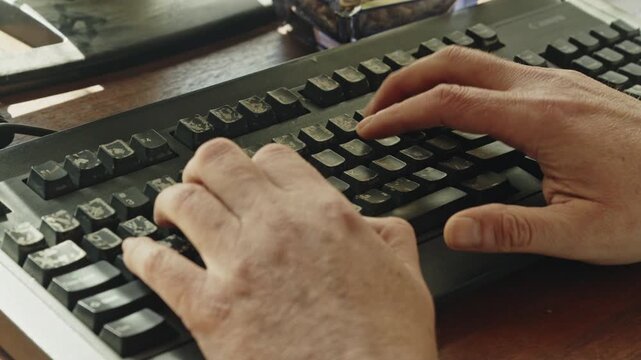 Deliberate typing on a computer keyboard suggests concentration, report writing, research, administration, or creative work in a calm professional environment.