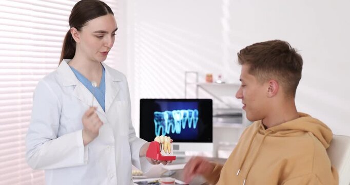 Doctor consulting man regarding dental implantation in clinic