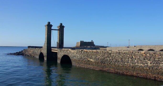 Shot of Puente de las Bolas, bridge of balls, with Castillo de San Gabriel in background. At Arrecif.