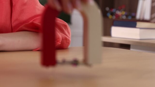 Student showing effect of magnetic field using horseshoe magnet and sewing pins at physics lesson in classroom, closeup