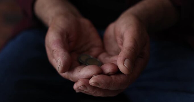 Poverty. Woman giving coins to homeless senior man indoors, closeup. Camera moving forward