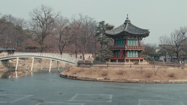 Scenic View of the Hyangwonjeong Pavilion and its Arched Wooden Bridge on a Frozen Pond at Gyeongbokgung Palace in Seoul(1).mov