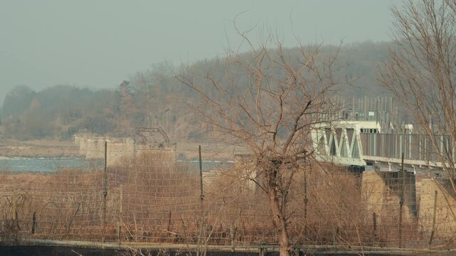 Military Barbed Wire Fence and the Dokdo Bridge Pier Ruins Near the Demilitarized Zone in Paju, South Korea