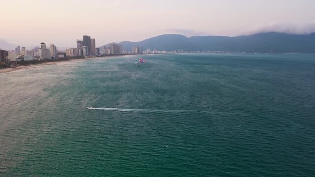 Aerial Drone Follow Tracking of Parasailing Above Turquoise Sea in Da Nang Vietnam