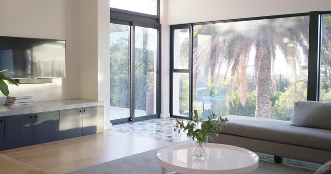 Camera is shifting right to reveal sofa chaise and coffee table while sunlight is brightening room