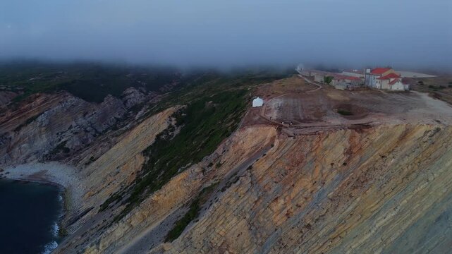 Low altitude drone pass over rough textured rocky cliff surfaces showing warm earth tones and natural mineral patterns
