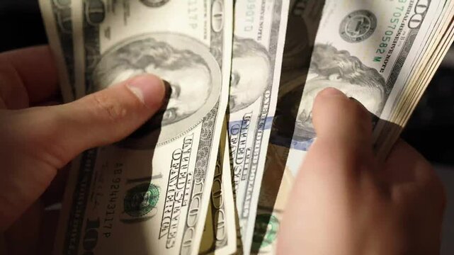 Trending Man Counting Dollars Cash Money Wealth Business Economy Financial Transactions in 4K Ultra HD footage.
